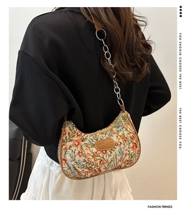 Floral nylon crescent bag with brown leather trim and metal chain strap detail