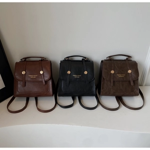 Detailed macro view of vintage mini backpacks in caramel, black, and coffee matte leather