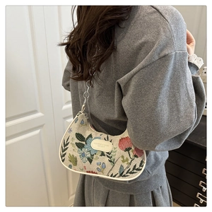 Détail de la broderie florale et de la chaîne en métal argenté du sac à bandoulière