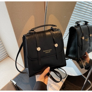 Close-up of black glossy PU leather backpack with gold metal buckles and fine texture