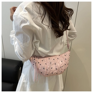 Detail view of pink crescent bag with bow embroidery and wrinkled fabric texture
