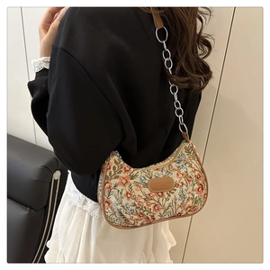 Détail du sac sous l'aisselle en toile florale avec forme croissant et bordure cuir