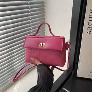 Rose pink embossed kelly bag with gold twist lock and elegant top handle shown in daylight