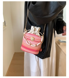 Détail du sac seau tressé dégradé avec bouton perle et chaîne en plastique