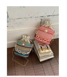 Detail of woven straw bucket bags with pearl charms and resin chain straps for summer