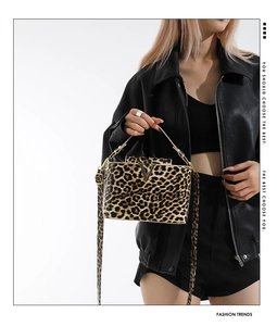 Detail of leopard print crossbody bag with metallic V-logo and chain strap detail