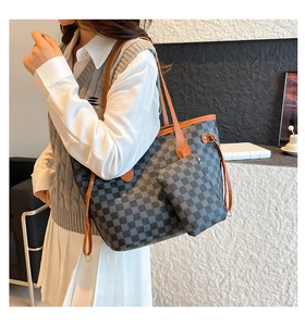 Detail of checkered tote bag set with brown leather straps and adjustable side drawstrings