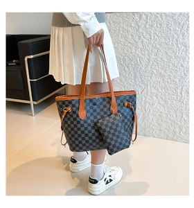 Dettaglio della borsa tote a scacchi e mini pochette coordinata con finiture in pelle marrone