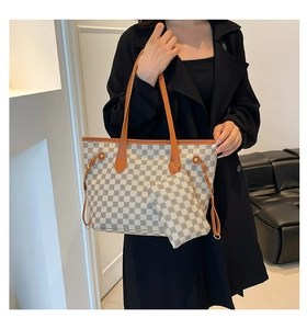 Dettaglio borsa shopper a scacchi con cinturini in pelle marrone e mini pochette