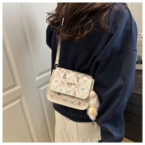 Detail of trendy cartoon print crossbody bag with cute plush rabbit pendant and gold logo