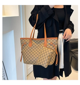 Dettaglio borsa shopper a quadri kaki con finiture in pelle arancione e mini borsa