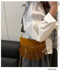 Détail du sac en daim marron avec franges et bandoulière brodée de style bohème