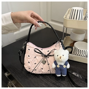 Pink pleated handbag with black bows, heart pendant, and teddy bear charm detail