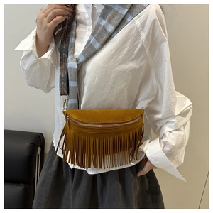Détail d'un sac bandoulière jaune bohème avec franges et bandoulière à motif ethnique