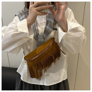 Detailed view of a brown tassel bag featuring an ethnic printed crossbody strap