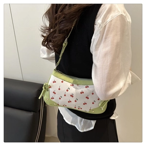Detail of light green leather trim and cherry print on white silk shoulder bag