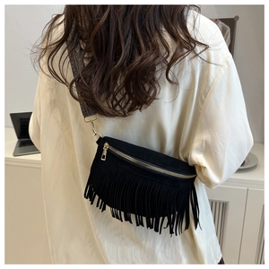 Détail d'un sac à franges noir avec une bandoulière tissée jacquard style bohème