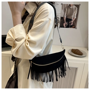 Détail d'un sac demi-lune noir à franges avec de longues franges et zip doré