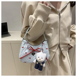 Détail du sac croissant bleu clair avec nœuds rouges et charmant ours en peluche