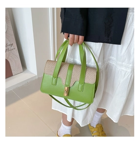 Detail of green leather and beige woven fabric tote bag with golden metal lock