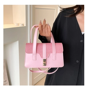 Detail of pink handbag with gold twist lock and mixed leather and woven textures