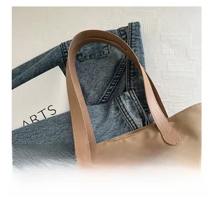 Close-up of durable reinforced synthetic leather handles on a khaki tote shopping bag