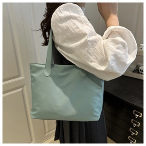 Detailed view of light blue tote bag showing durable fabric and long shoulder handles