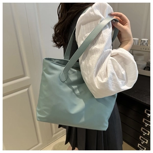 Minimalist mint green tote bag shoulder view showing large capacity and fabric texture