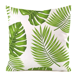 Detail of tropical monstera leaf print on a white faux silk decorative cushion cover