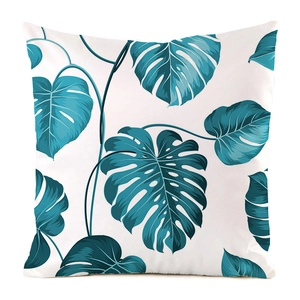 Detail of silk square cushion cover featuring blue monstera leaf pattern on white background