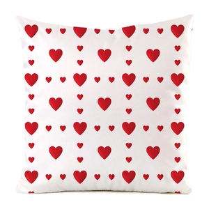 Detailed close-up of decorative square pillow cover with red heart print and silk texture