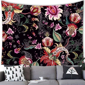 Bohemian wandtapijt met paisley bloemen op zwarte stof boven een woonkamerbank