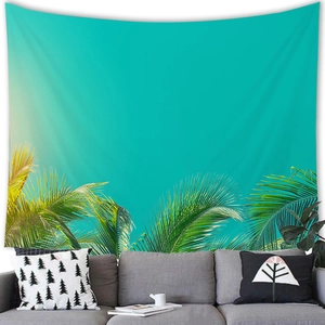 Tropical palm leaves tapestry on bright teal background above a modern sofa
