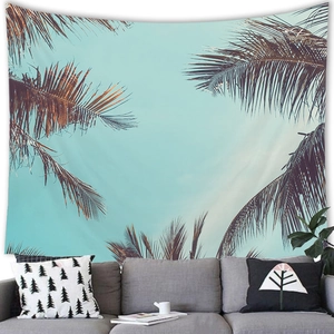 Tropical coconut tree tapestry hanging over a gray sofa in a modern living room