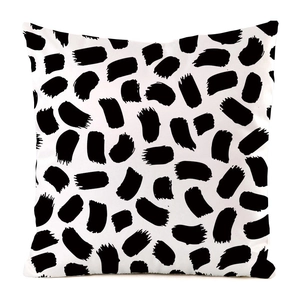 Detail of white throw pillow cover featuring modern black irregular brush stroke pattern