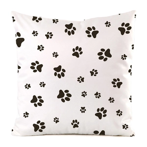 Detailed view of the cute black paw print pattern on the white faux silk cushion cover