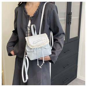 Detail of light blue lace backpack with bow accent and drawstring closure
