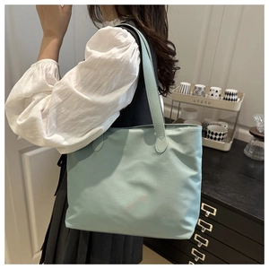 Asian model wearing a minimalist light blue tote bag in a stylish home interior setting