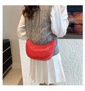 Détail du sac demi-lune rouge tissé avec une chaîne dorée fine et une fermeture éclair