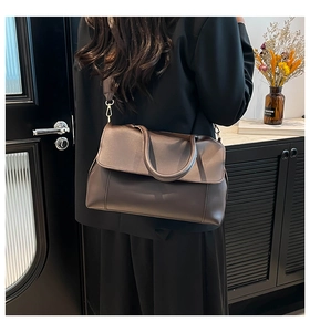 Deep brown faux leather tote bag with round handle and gold hardware on wide strap