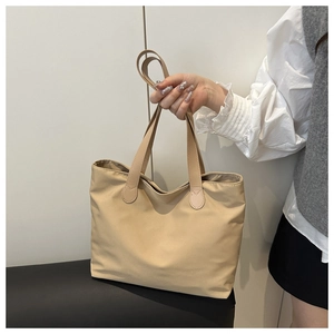 Detail view of khaki nylon tote bag showing durable fabric and long shoulder handles