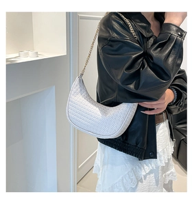 Dettaglio della borsa hobo bianca intrecciata con elegante catena dorata e design a luna