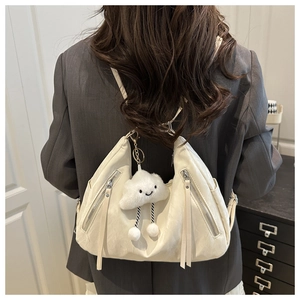 Chic off-white crescent tote bag with fringe zippers and cloud charm on a shoulder