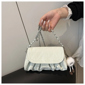 Detail of off-white pleated chain bag with fashion logo and cute plush doll charm