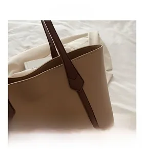 Dettaglio borsa tote in pelle beige con manici marroni e cuciture rifinite a mano