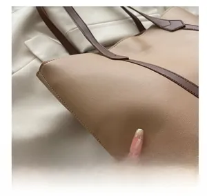 Dettaglio della trama in pelle e delle cuciture a contrasto della borsa tote beige