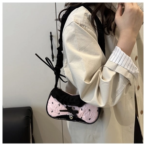 Détail du sac bandoulière rose et noir avec motif lapin, bordure dentelle et pendentif