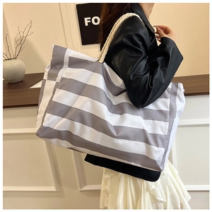 Detail of large striped tote bag with thick cotton rope handles and woven canvas texture