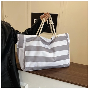 Detail of grey and white striped canvas tote with durable thick rope handles and metal eyelets