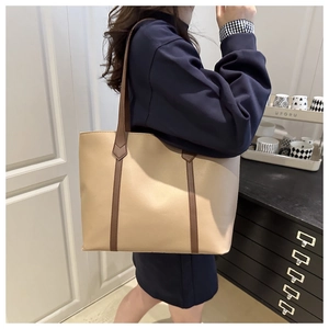Modella che indossa una grande borsa tote in pelle PU beige con manici marroni scuri